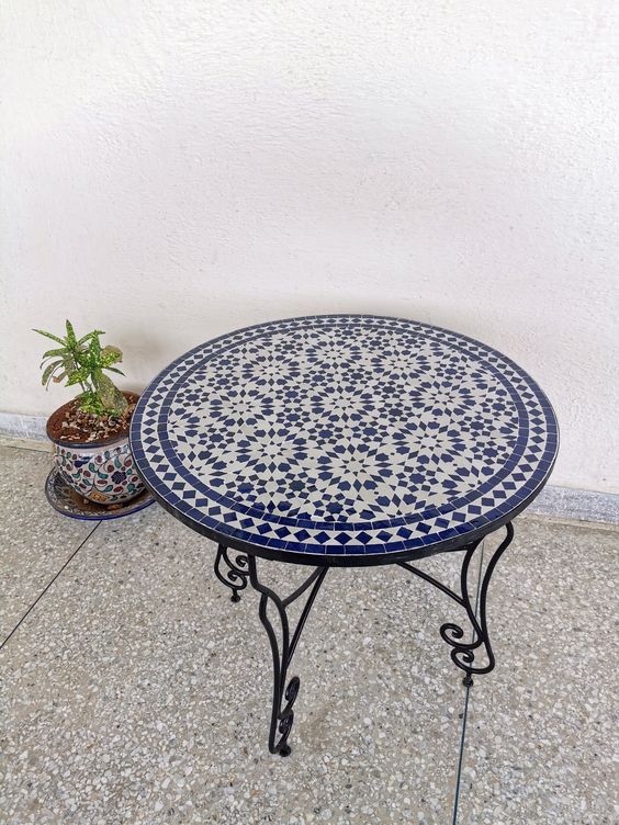 A mosaic table top with a potted plant, showcasing a beautiful blend of blue and white colors
