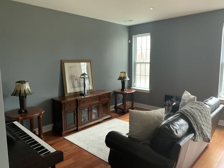 A Steely Gray living room with a piano and windows, creating a serene and elegant ambiance