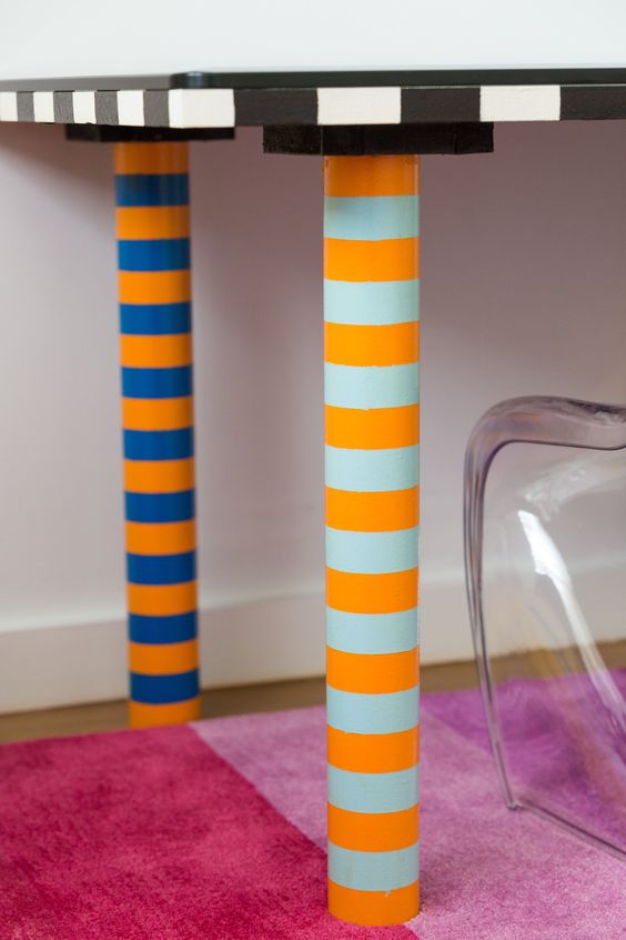 A table with vibrant striped legs and a matching chair. A perfect combination of colors and patterns