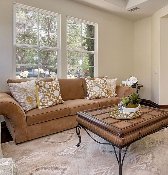A cozy living room with a beige couch, coffee table, and a window offering a view