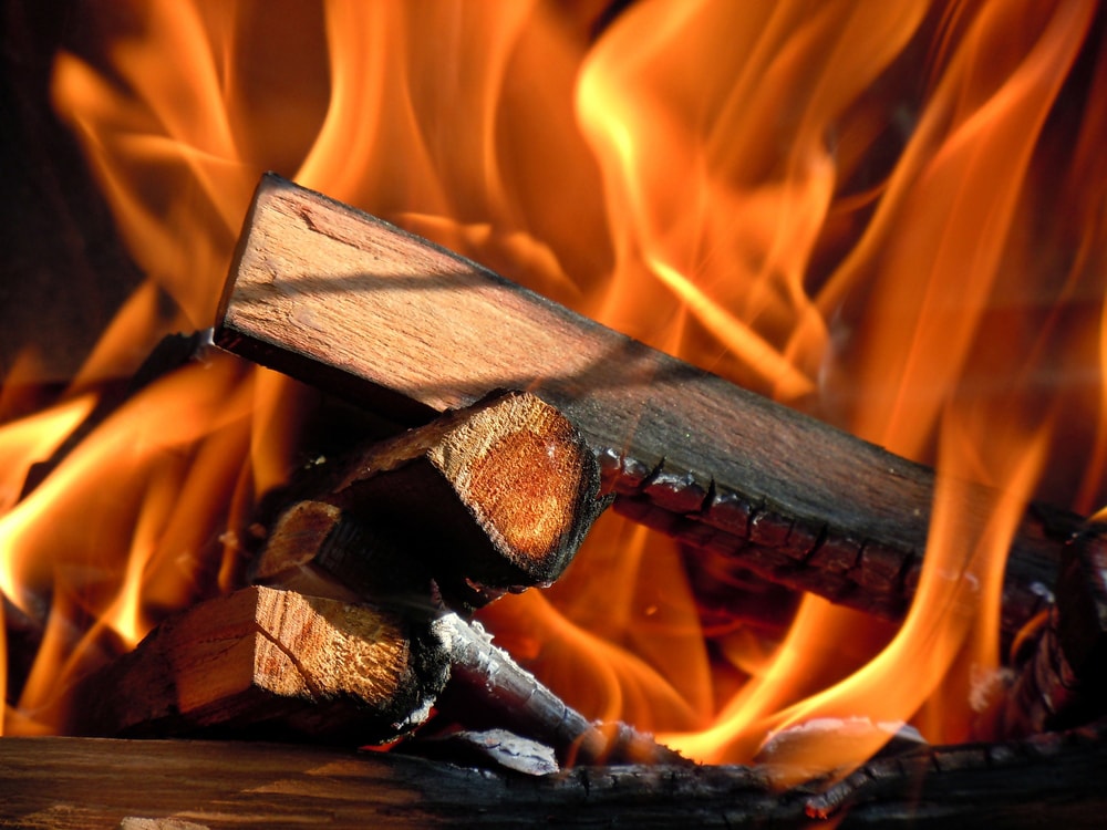 A close-up of a fire with logs and wood, providing warmth and ambiance. Can you burn pine in a fireplace