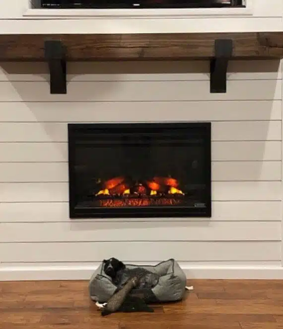 A simple white wooden mantel with a fireplace beneath it