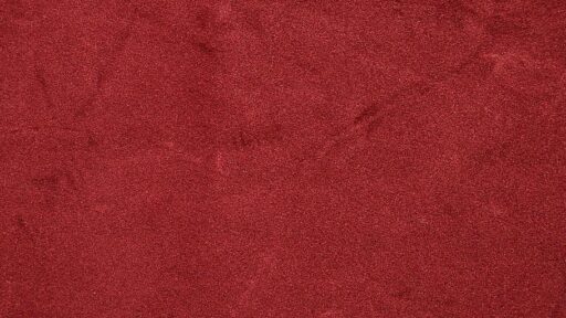 A close-up of a red fabric texture background, showcasing the rich and vibrant color of velve