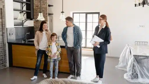 Free Family exploring a newly purchased home interior with real estate agent. Stock Photo