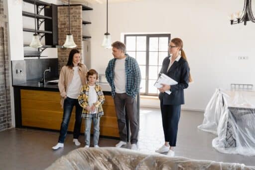 Free Family exploring a newly purchased home interior with real estate agent. Stock Photo