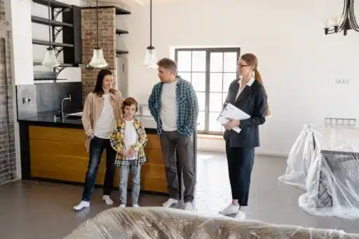 Free Family exploring a newly purchased home interior with real estate agent. Stock Photo