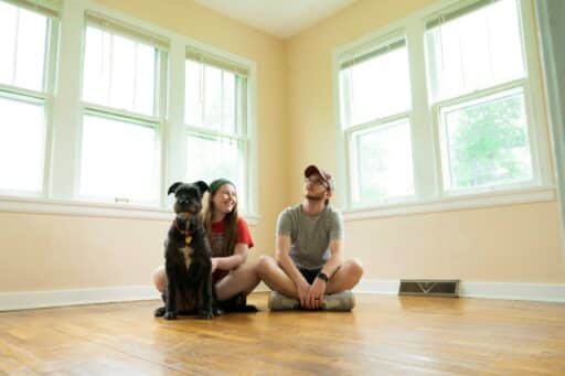 woman in gray shirt sitting on brown wooden floor