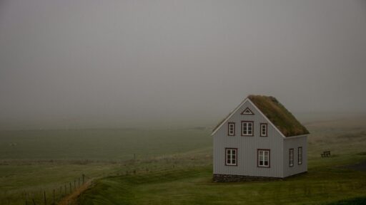 a white house on a grassy hill