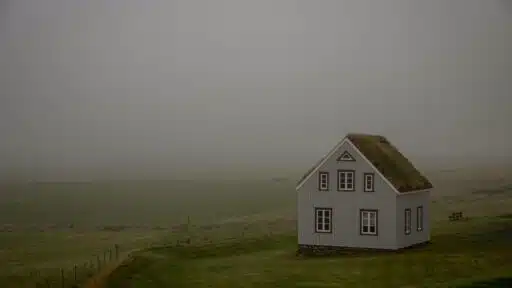 a white house on a grassy hill