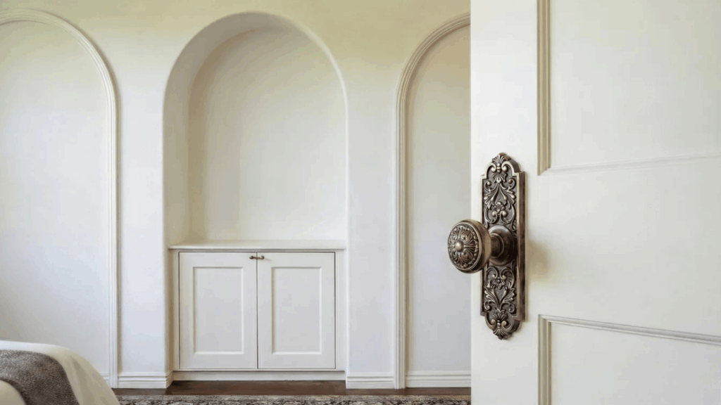 close-up of an ornate brass door knob on a white paneled door