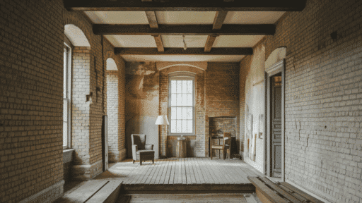 interior of an old american home with exposed brick walls peeling plaster and original wood beam ceiling