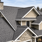 Modern house with gray asphalt shingle roof, multiple gables, and chimney in a suburban setting