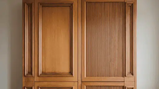 a finished shaker cabinet door and a fluted cabinet door installed side by side on a wall with warm amber lighting
