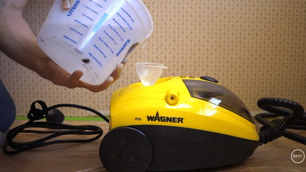 a person setting up the steamer and pouring water in it, in a room