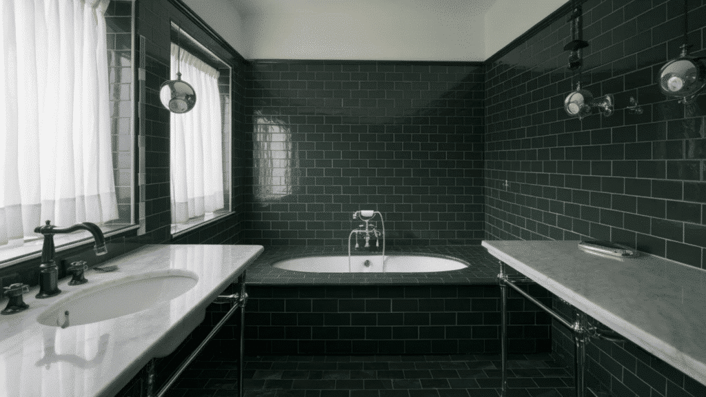 bathroom with glossy dark green subway tile walls, a built in soaking tub with chrome fixtures, marble countertops on both sides with sinks, black faucet hardware, and a window with white curtains