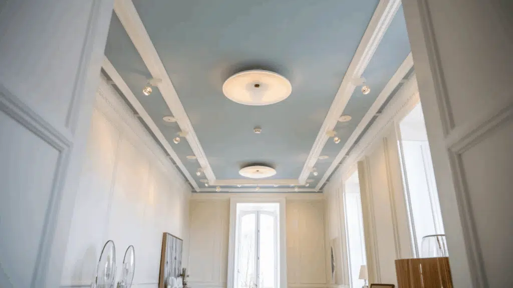 blue ceiling with recessed lighting and decorative molding in a bright, elegant room
