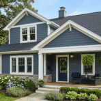 blue-gray house with white trim, gabled roof, cozy front porch, and hydrangea-lined garden.
