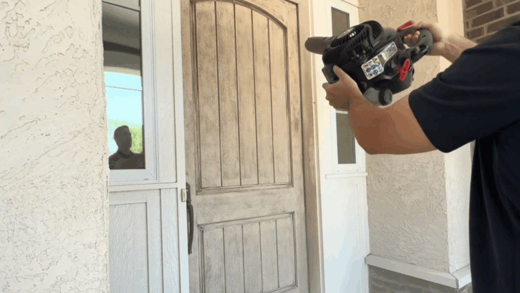 close-up of a hand with leaf bowler remove dust from the sanded door