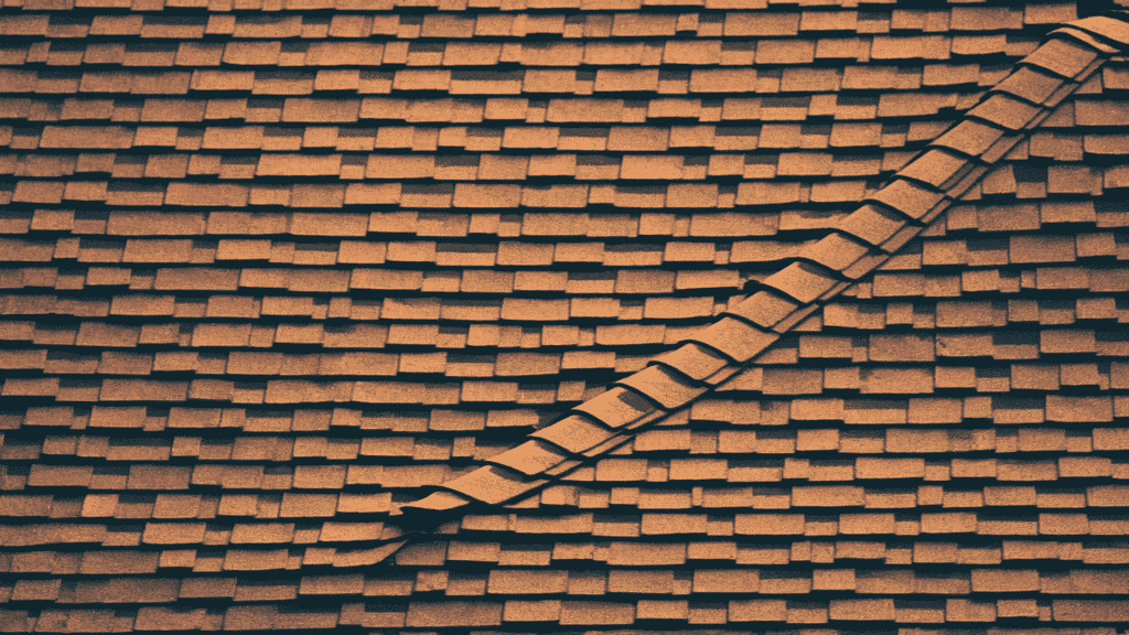 close-up of old organic asphalt roof shingles with layered texture and visible wear along roof ridge line
