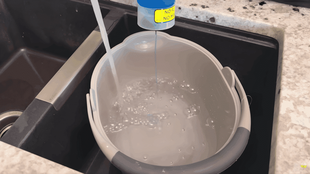 filling bucket with water and cleaner for cabinet cleaning.