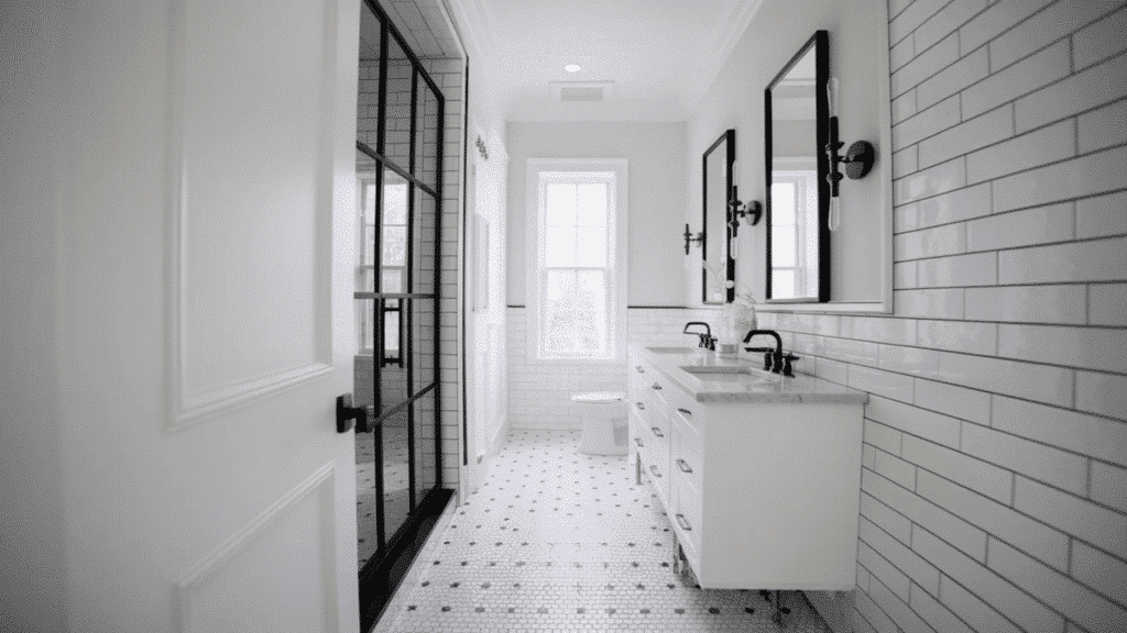 front view black and white bathroom with matte black sliding barn door, smooth white walls, vanity, and black fixtures. (1)