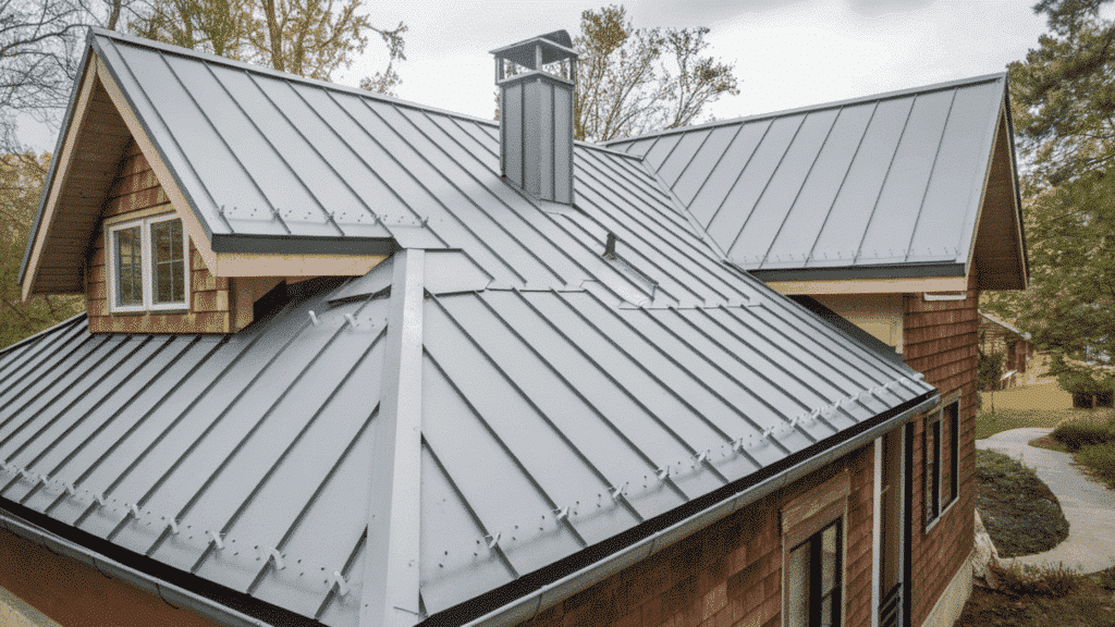 gray standing seam metal roof on modern home with chimney, dormers, and clean vertical panel design