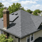 house with hip roof asphalt shingles pyramid-style roof with chimney and solar panels suburban neighborhood