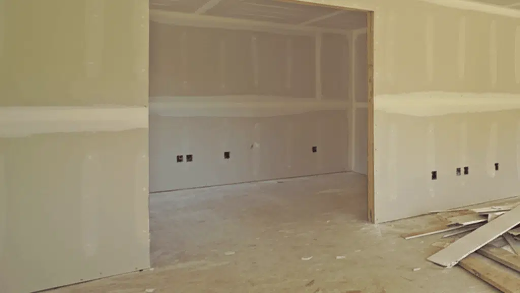 image of drywall installation in a room with visible seams and edges, showing the preparation before finishing and painting