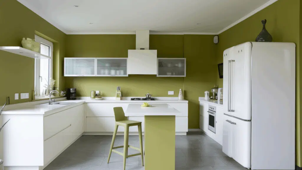 kitchen with olive green walls, white cabinets, island seating, and retro white fridge.