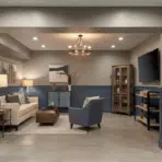 light gray basement walls with deep blue wainscoting and trim, cozy seating area, clean contrast, and warm layered lighting