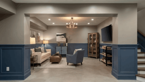 light gray basement walls with deep blue wainscoting and trim, cozy seating area, clean contrast, and warm layered lighting
