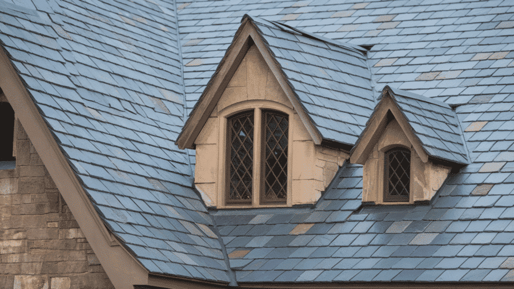 luxury slate roof shingles on historic home with dormer windows and detailed stone exterior architecture