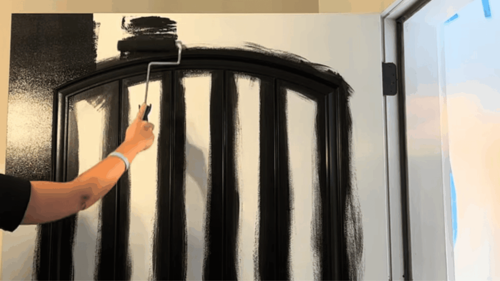 paint roller applying black semi-gloss paint to a door panel