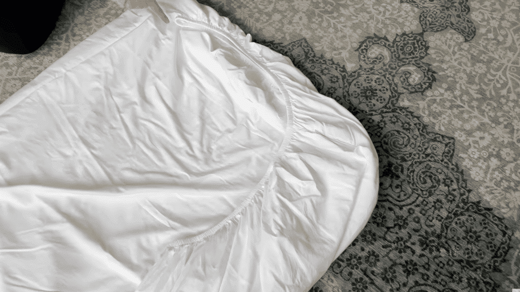 placing sheet on surface and shaping it into a neat rectangle by tucking loose edges