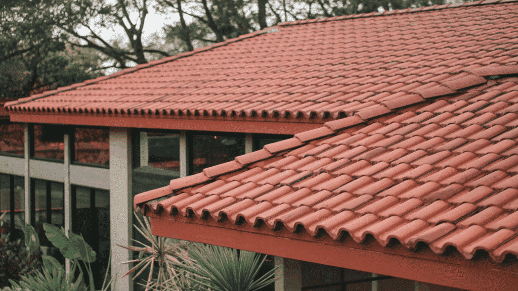red concrete tile roof on modern home with curved barrel tiles and landscaped yard in background