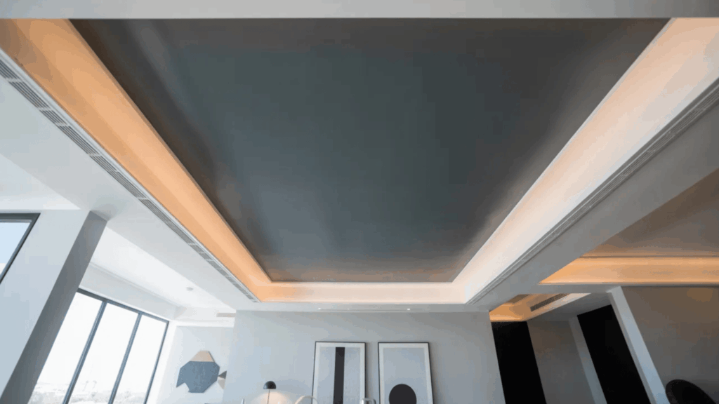 sleek, modern ceiling with recessed lighting and a dark, matte finish, complemented by large windows