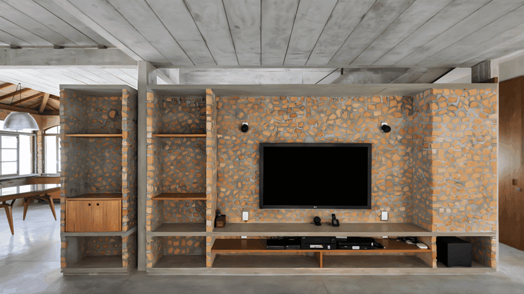 sustainable interior wall made with reused bricks featuring built in shelving and tv unit with natural materials and minimalist design