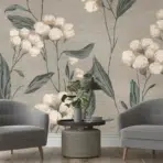 two gray armchairs with a small round table and plant set against a soft floral wallpaper background in a cozy room