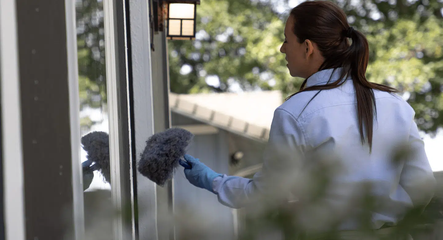 Woman checking the window sill.