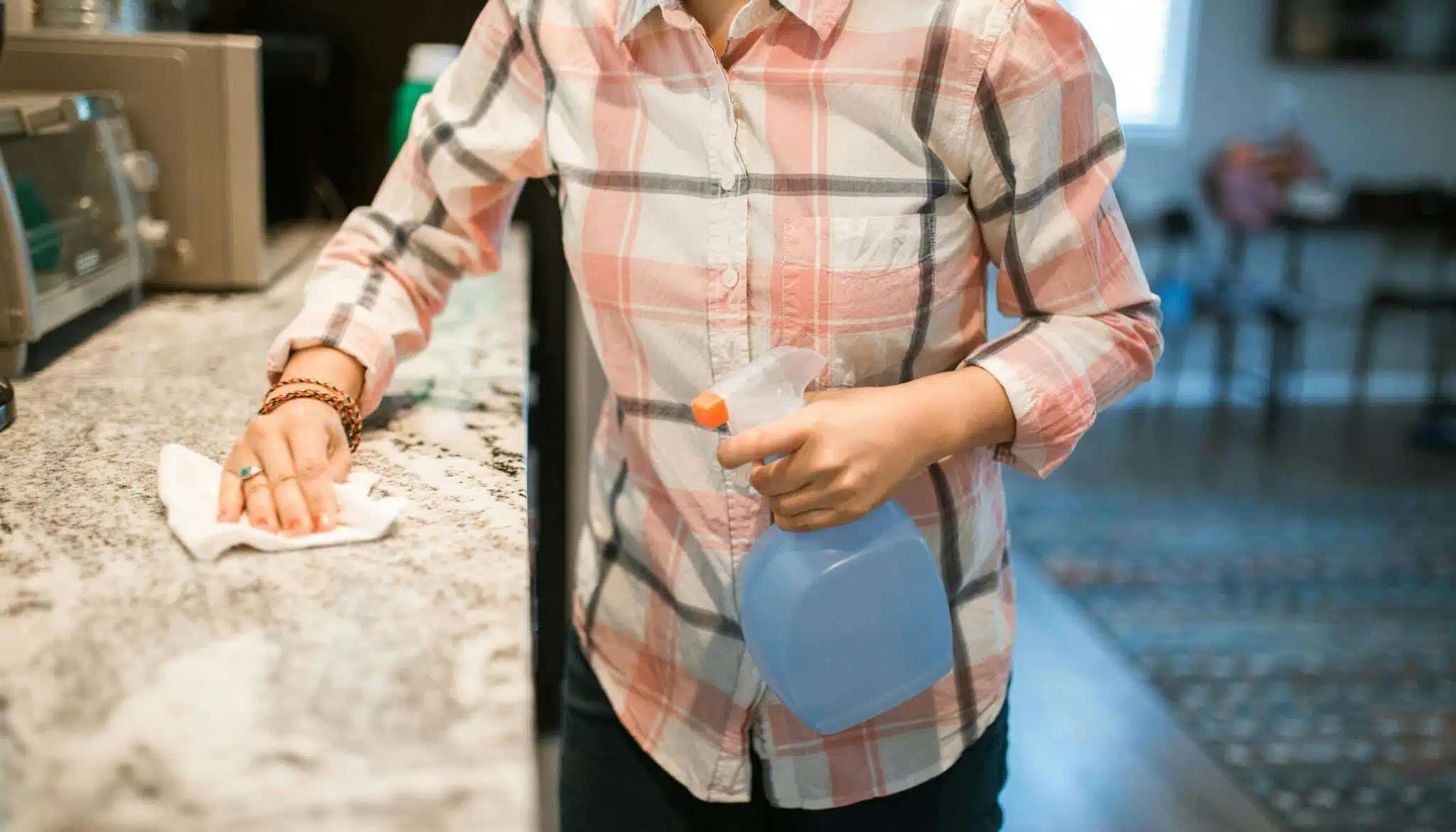 A person wiping a kitchen counter.