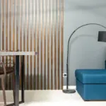 Modern living room with blue sofa, black floor lamp, and wooden slatted wall divider