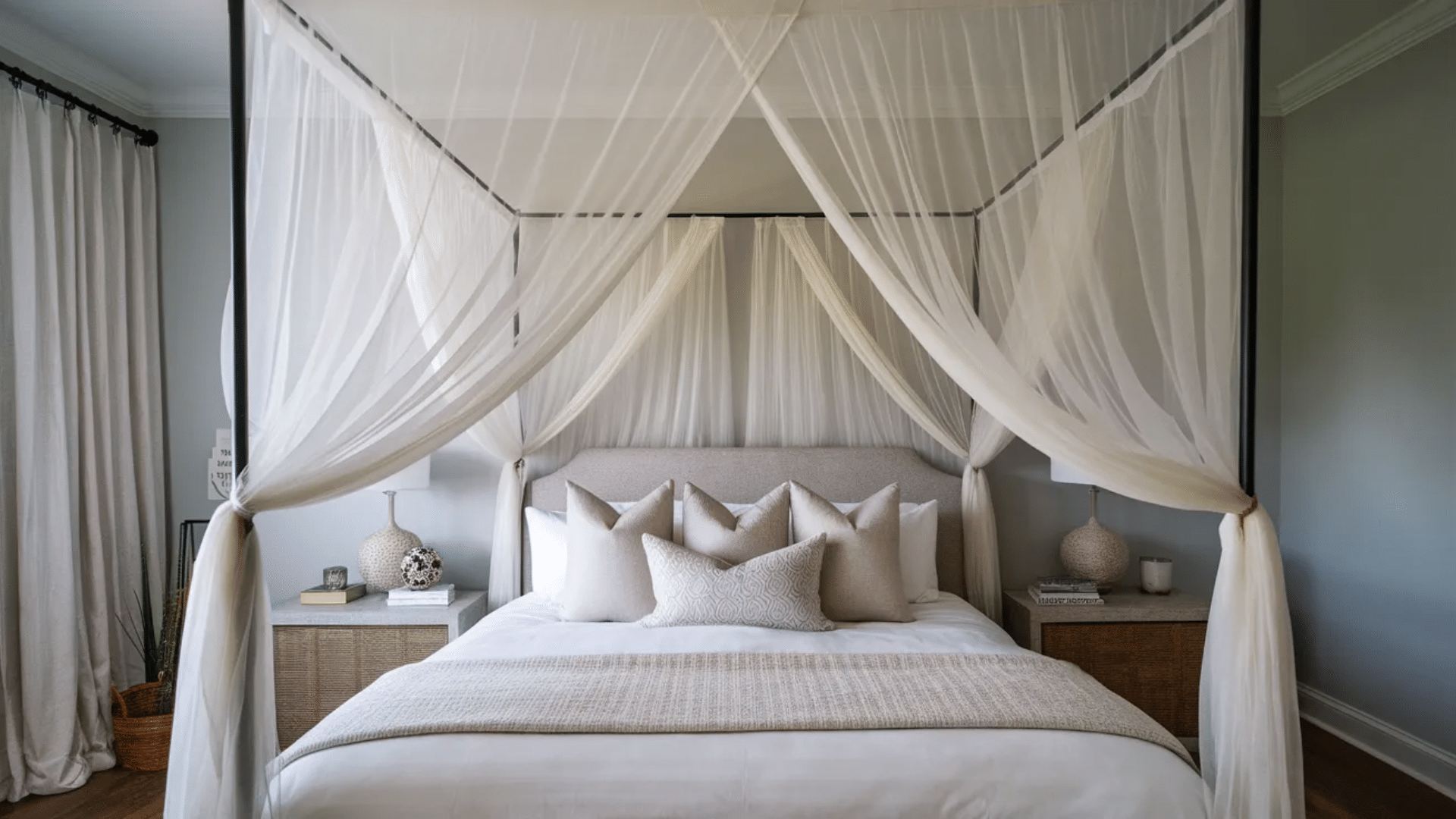 a serene bedroom with a canopy bed draped in soft white sheer fabric, decorated with neutral-toned pillows and a cozy woven blanket, creating a calming atmosphere.