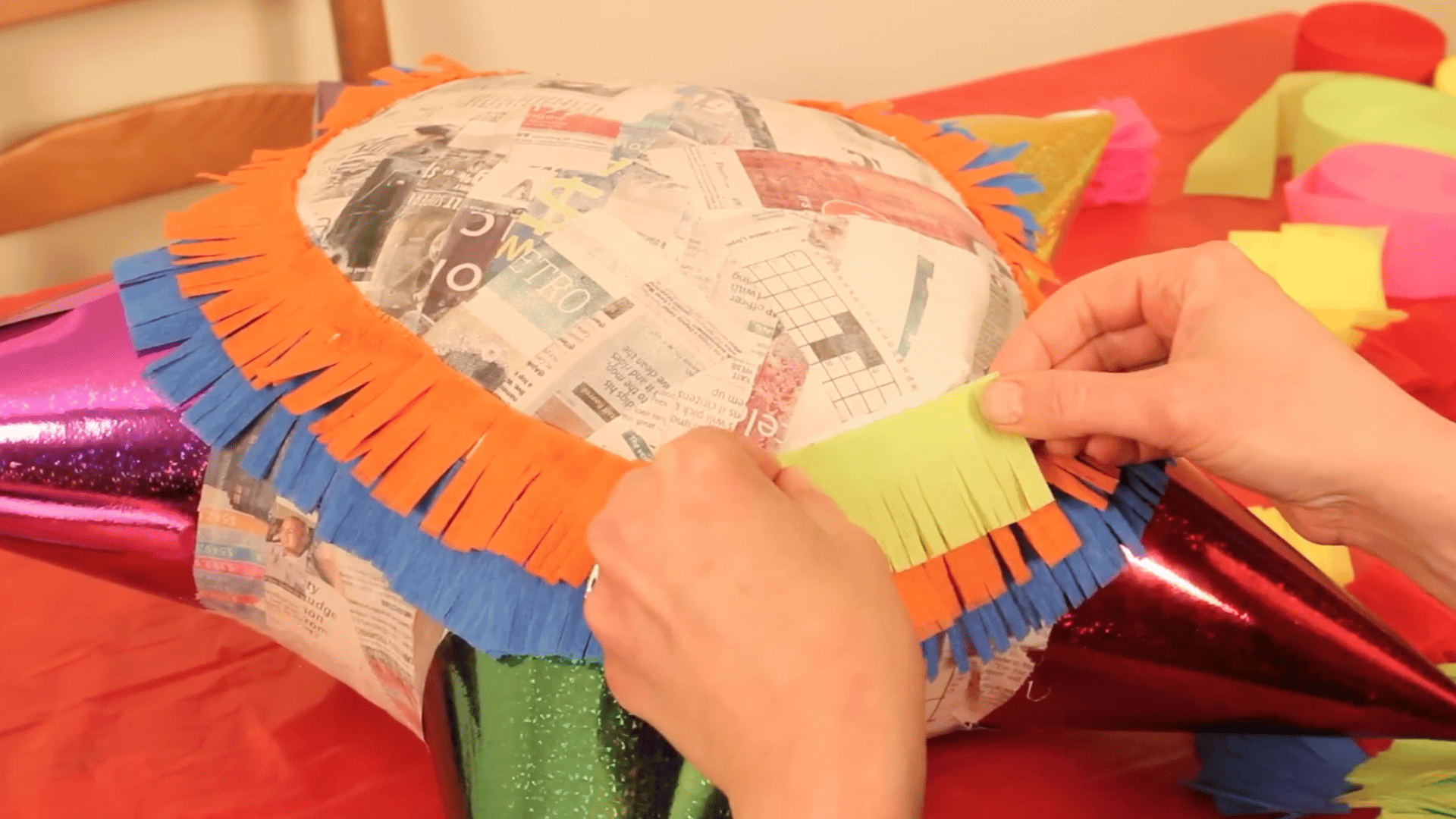 adding colorful fringe paper with glue in layers to decorate and cover the entire surface