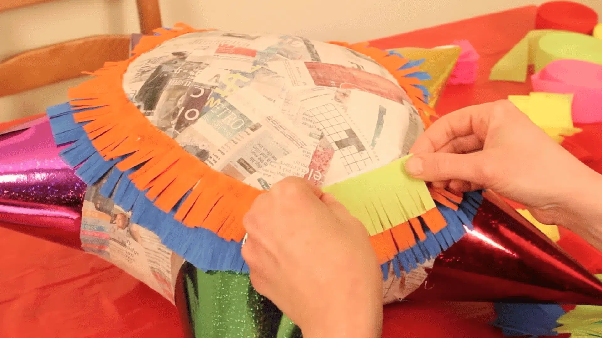 adding colorful fringe paper with glue in layers to decorate and cover the entire surface