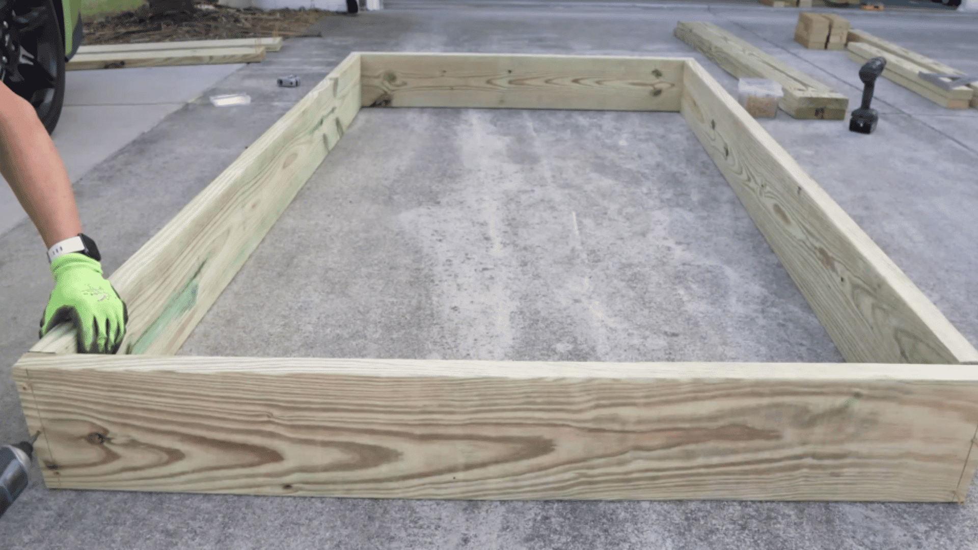 assembling first frame layer with screws on flat driveway surface