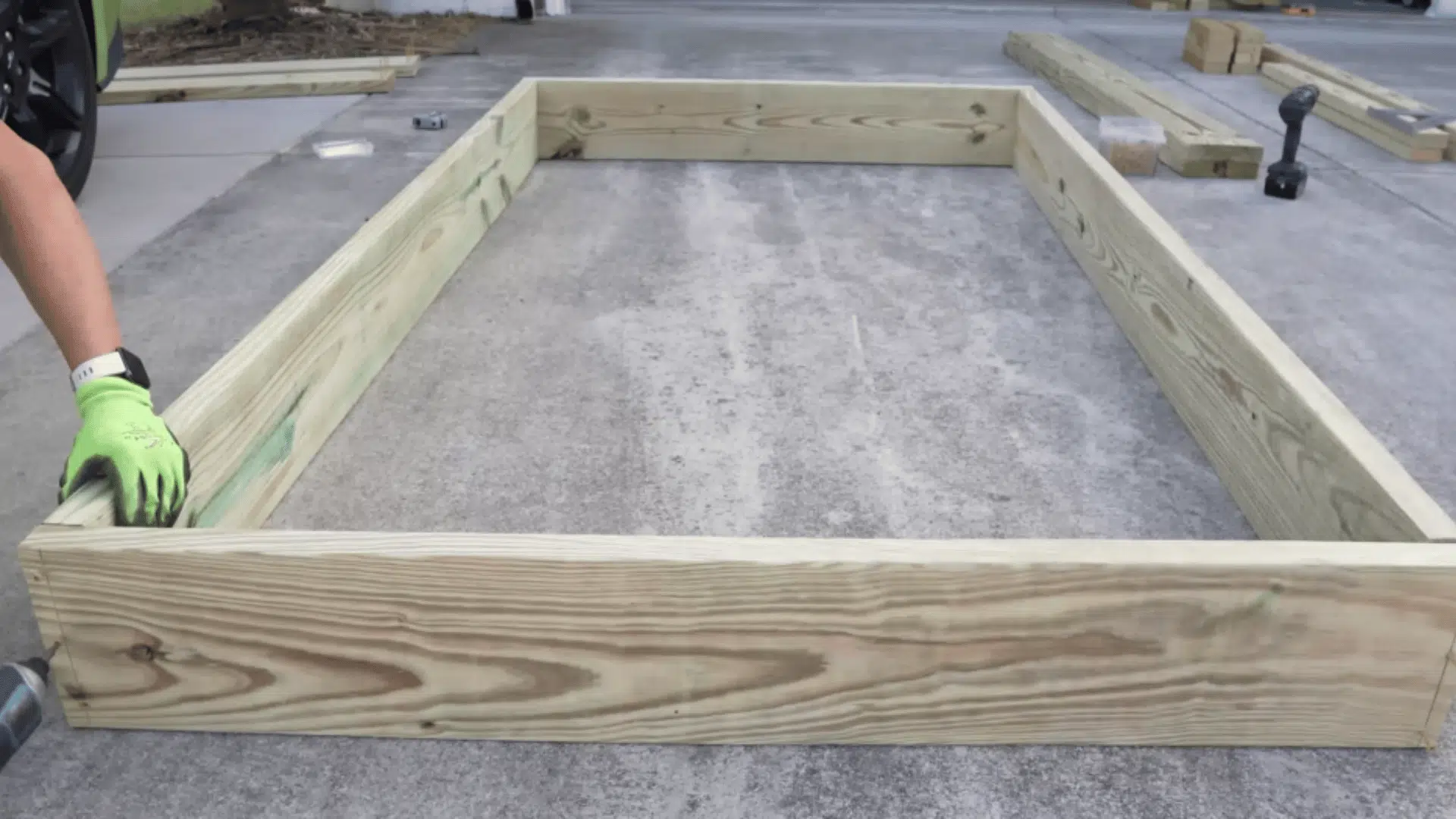 assembling first frame layer with screws on flat driveway surface
