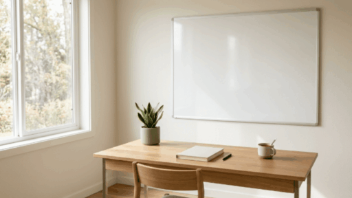 clean whiteboard mounted on wall above wooden desk with notebook, coffee mug, and indoor plants in a bright workspace