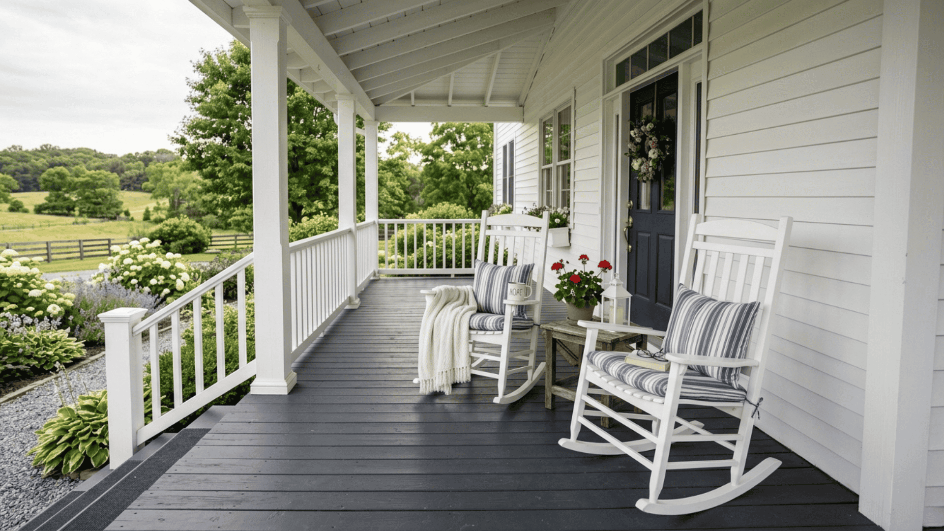 deep charcoal painted farmhouse porch floor with white railings columns and two white rocking chairs