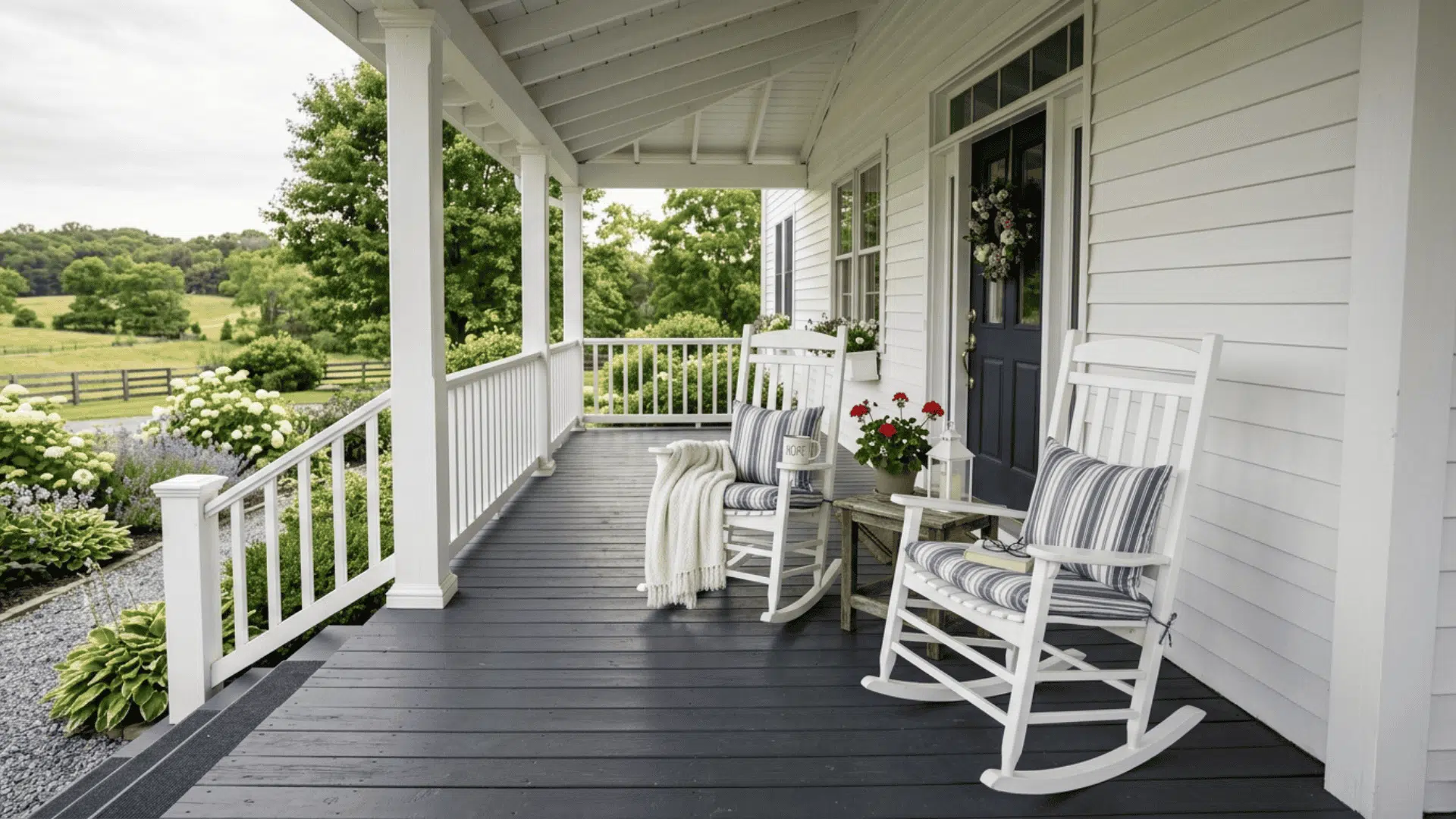deep charcoal painted farmhouse porch floor with white railings columns and two white rocking chairs