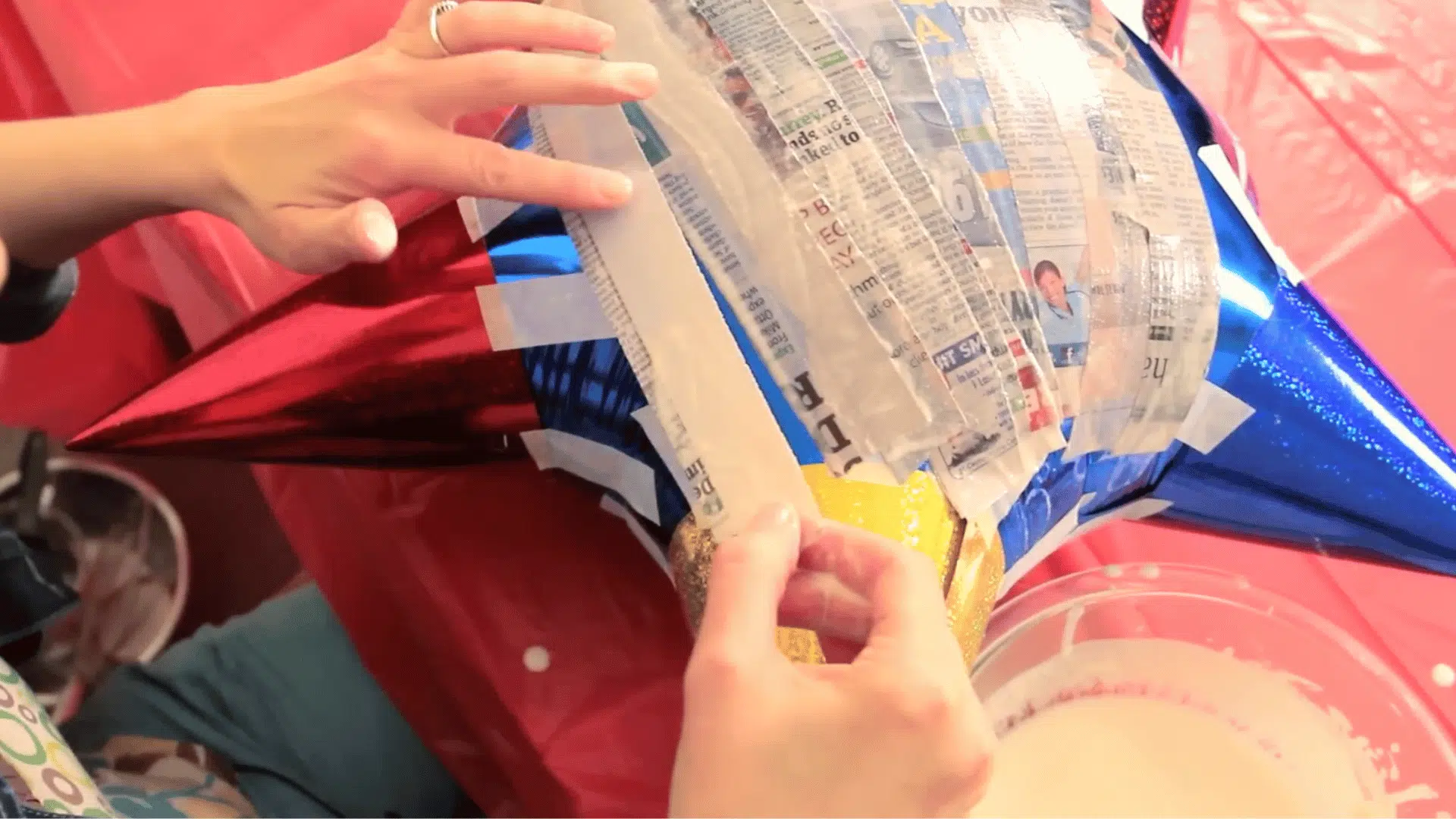 dipping newspaper strips in paste and applying evenly over balloon with slight overlap (1)